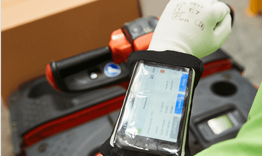 Munkás okostelefonos alkalmazást használ raktárban.